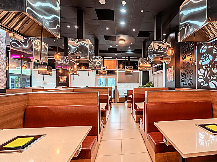 KOSOO Coquitlam interior aisle with leather booth seating and modern lighting